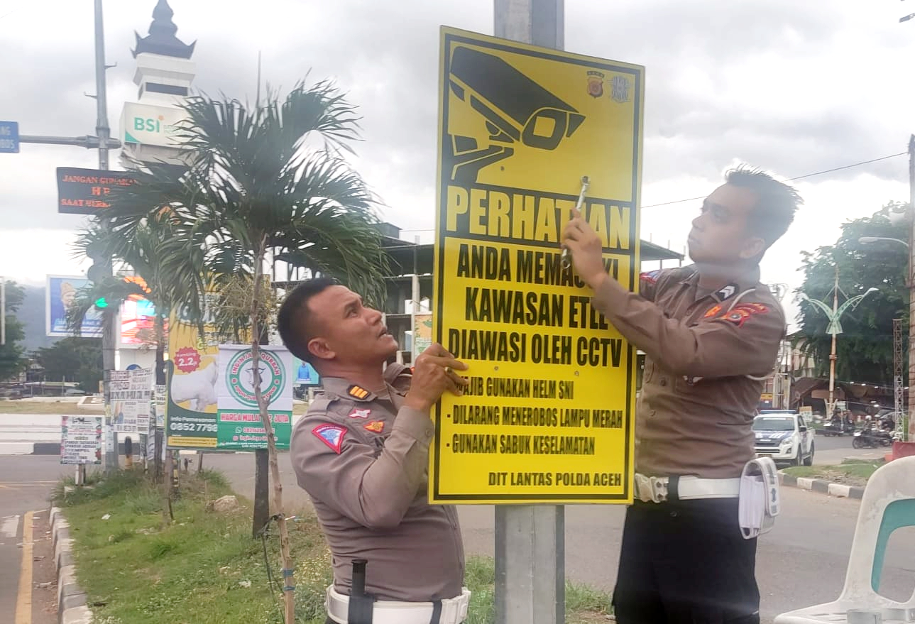 Personel Ditlantas Polda Aceh memasang papan rambu peringatan electronic traffic law enforcement (ETLE) di sejumlah titik traffic light di Kota Banda Aceh, Jumat, 3 Mei 2024. FOTO/Orinews/Maulya. Ⓒ Hak cipta foto di atas dikembalikan sesungguhnya kepada pemilik foto