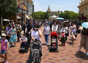 Pengunjung Mengenakan Masker Berjalan Di Hong Kong Disneyland, Kamis 21 April 2022. Hong Kong Disneyland Dibuka Kembali Untuk Umum Setelah Ditutup Akibat Lonjakan Infeksi Covid-19.