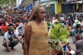 Seorang mama-mama Papua melintasi ratusan mahasiwa yang mengikuti aksi di Lingkaran Abe, Distrik Abepura, Kota Jayapura, Papua, Jumat (1/4/2022). Akso tersebut untuk menolak pemekaran Daerah Otonomi Baru (DOB) di Papua.