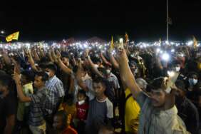 Warga Sri Lanka mengangkat ponsel mereka saat berjaga mengutuk penembakan polisi terhadap pengunjuk rasa di Rambukkana, 90 kilometer (55 mil) timur laut Kolombo, pada protes di luar kantor presiden di Kolombo, Sri Lanka, Selasa, 19 April 2022. Sri Polisi Lanka Selasa melepaskan tembakan ke sekelompok orang yang memprotes kenaikan harga bahan bakar baru, menewaskan satu orang dan melukai 10 lainnya, dalam penembakan pertama oleh pasukan keamanan selama berminggu-minggu demonstrasi atas krisis ekonomi terburuk negara itu dalam beberapa dasawarsa.