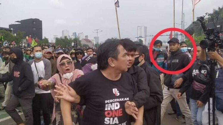 Pria yang dilingkari mark warna merah terekam memukul Ade Armando dari belakang. Setelahnya massa terpancing memukuli Ade Armando (Foto: dok istimewa/tangkapan layar video. FOTO/Tangkapan Layar