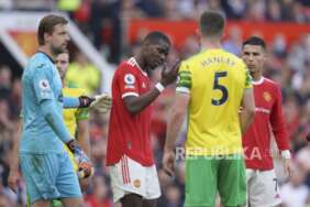 Pemain Manchester United Paul Pogba menyeka darah dari wajahnya selama pertandingan sepak bola Liga Inggris antara Manchester United dan Norwich City di stadion Old Trafford di Manchester, Inggris, Sabtu (16/4/2022).