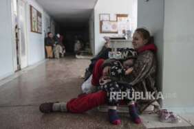Anastasia Erashova menangis saat memeluk anaknya di koridor sebuah rumah sakit di Mariupol, Ukraina timur pada Jumat, 11 Maret 2022. Anak Anastasia lainnya tewas dalam penembakan di Mariupol.