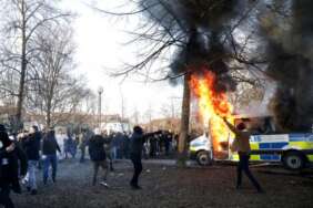 Para pengunjuk rasa membakar bus polisi di taman Sveaparken di Orebro, Swedia, Jumat, 15 April 2022.