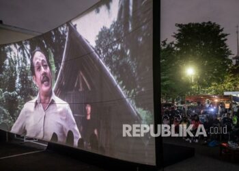 Warga menyaksikan pemutaran film Si Doel Anak Betawi karya Sjuman Djaya di halaman Perusahaan Umum Produksi Film Negara (Perum PFN), Jakarta, Kamis (31/3/2022). Perum PFN mengadakan kegiatan bioskop rakyat dalam rangka memperingati Hari Film Nasional 2022.