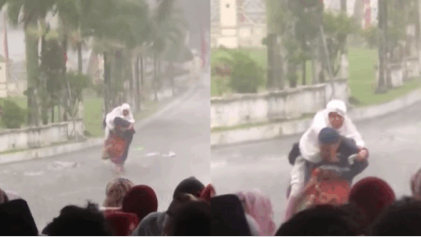 Mengharukan! Anak Gendong Ibunya untuk Berteduh Saat Salat Ied Diguyur Hujan