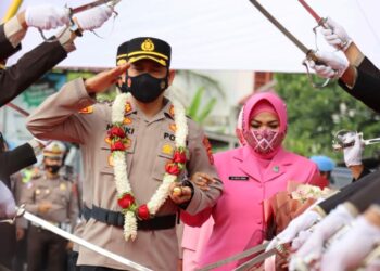 AKBP Henki Ismanto saat bersama istri Resti Henki memasuki gerbang Polres Lhokseumawe. FOTO/Dok. Polres Lhokseumawe