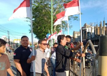 Pemuda Drien Rampak Dibantu Tni Memasang Bendera Merah Putih Di Jalan Gajah Mada Meulaboh, Foto/Ist