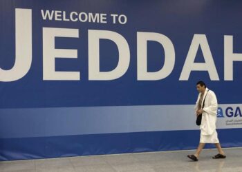 Platform Nusuk Diluncurkan Arab Saudi Untuk Permudah Umroh. Foto: Seorang Jamaah Haji Berjalan Di Depan Spanduk Penyambutan Setibanya Di Bandara Internasional King Abdulaziz Di Jeddah, Arab Saudi, Jumat, 1 Juli 2022.