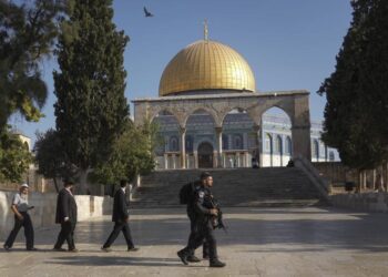 Petugas polisi Israel mengawal sekelompok pria Yahudi untuk mengunjungi Temple Mount, yang dikenal oleh umat Islam sebagai Suaka Mulia, di kompleks Masjid Al Aqsa di Kota Tua Yerusalem, selama ritual berkabung tahunan Tisha BAv (kesembilan of Av) hari puasa dan hari peringatan, memperingati penghancuran kuil kuno Yerusalem, Ahad, 7 Agustus 2022.