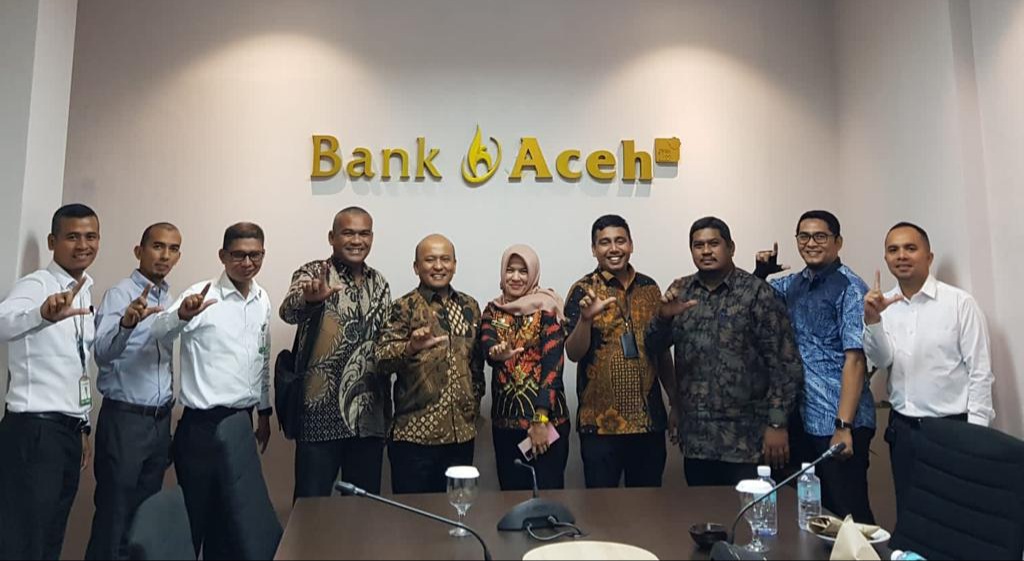 Pemimpin Divisi Treasury Bank Aceh, Erwin Konadi, Pemimpin Divisi Teknologi Informasi, Imamil Fadli, dan staf melakukan foto bersama dalam rangka kerjasama pembayaran PBB via Action dengan Badan Pengelola Keuangan Kota Banda Aceh, yang dihadiri oleh Sekretaris BPKK, Nella Vanessa, Kabid Penagihan, Safiran Nizar SE, Sekretaris UPTD PBB, ZulbahrinST, dan Kelapa TO BPKK Kota Banda Aceh, Muhammad Saleh, di Kantor Pusat Bank Aceh, Banda Aceh, 15 September 2022. FOTO/Dok. Bank Aceh Syariah