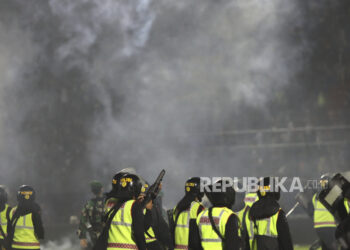 Petugas polisi menembakkan gas air mata saat kerusuhan setelah pertandingan sepak bola di Stadion Kanjuruhan di Malang, Jawa Timur, 01 Oktober 2022 (dikeluarkan pada 02 Oktober 2022). Tiga anggota polisi ditetapkan menjadi tersangka dalam tragedi yang menewaskan 131 orang ini. (ilustrasi)
