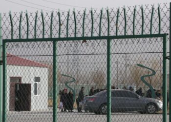 Warga berbaris di dalam Pusat Layanan Pelatihan Pendidikan Keterampilan Kejuruan Kota Artux yang sebelumnya telah terungkap oleh dokumen yang bocor menjadi kamp indoktrinasi paksa di Taman Industri Kunshan di Artux di wilayah Xinjiang China barat, 3 Desember 2018. China telah menanggapi dengan marah ke laporan PBB tentang dugaan pelanggaran hak asasi manusia di wilayah barat laut Xinjiang yang menargetkan Uyghur dan etnis minoritas Muslim lainnya.
