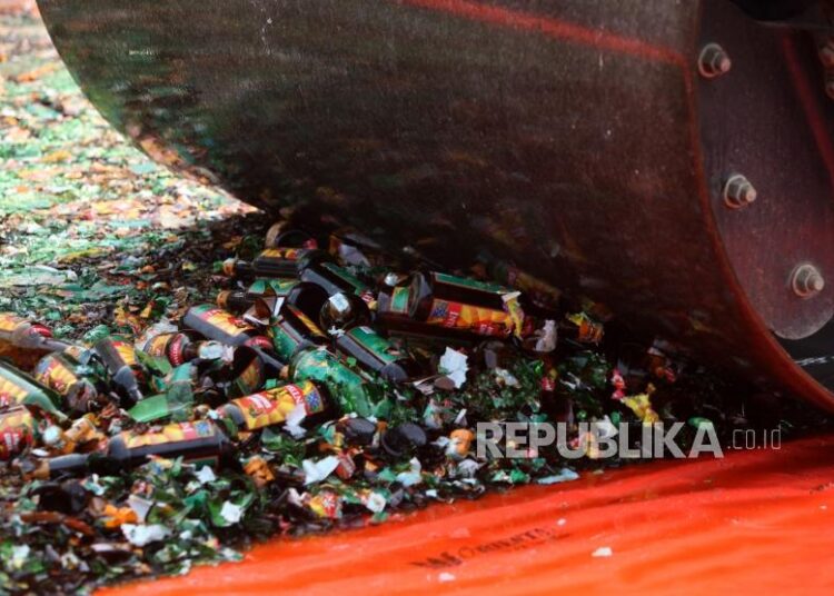 Petugas menggunakan buldoser memusnahkan ribuan botol minuman beralkohol. ilustrasi