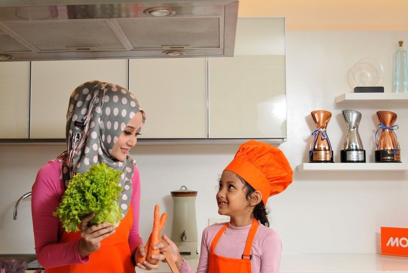 Ibu dan anak memasak di dapur (ilustrasi). Cara memasak yang tidak tepat dapat memicu risiko kanker.