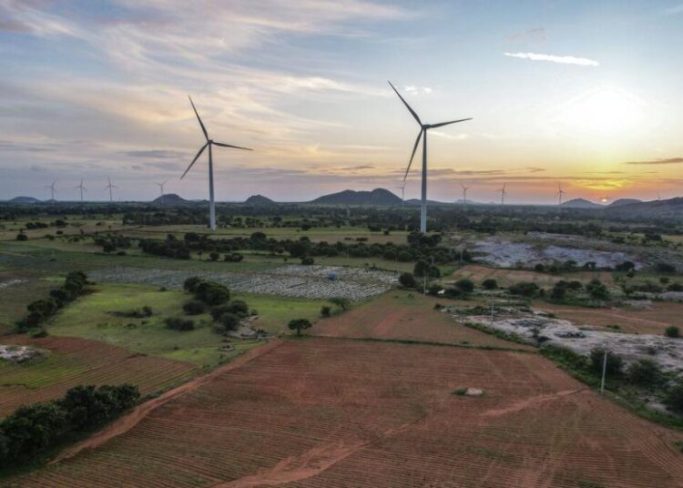 Sebuah peternakan kincir angin bekerja saat matahari terbenam di distrik Anantapur, Andhra Pradesh, India, Rabu, 14 September 2022. India berinvestasi besar-besaran dalam energi terbarukan dan telah berkomitmen untuk memproduksi 50?yanya dari sumber energi bersih pada tahun 2030.