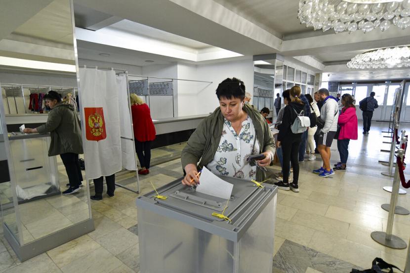 Orang-orang dari wilayah Luhansk dan Donetsk, wilayah yang dikuasai oleh pemerintah separatis pro-Rusia, yang tinggal di Krimea, memberikan suara selama referendum di Sevastopol, Krimea, Jumat, 23 September 2022. Pemungutan suara dimulai Jumat di empat wilayah yang dikuasai Moskow. Ukraina pada referendum untuk menjadi bagian dari Rusia.