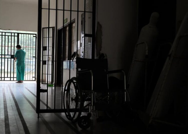 Seorang tenaga keperawatan yang bertugas menutup pintu gerbang ruang unit gawat darurat di kantor Rumah Sakit Jiwa ilustrasi