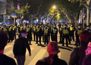 Petugas polisi China memblokir akses ke lokasi tempat para pengunjuk rasa berkumpul di Shanghai pada Ahad, 27 November 2022. Ibu kota China, Beijing, melaporkan 2.086 kasus Covid-19 baru lokal selama 15 jam, Senin (28/11/2022).
