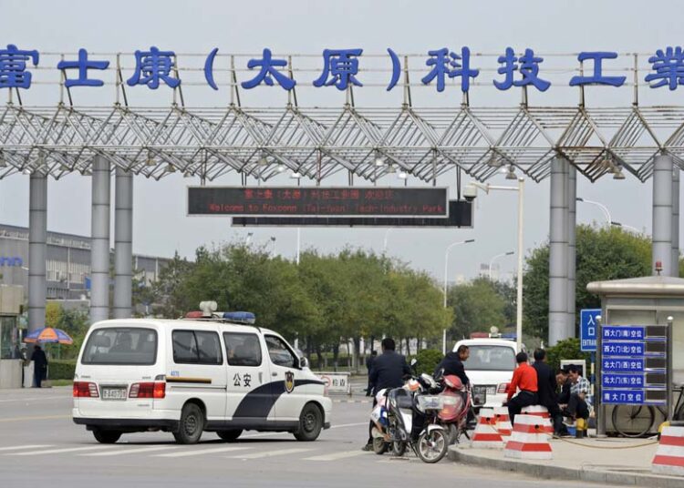 Kendaraan polisi diparkir depan pintu masuk pabrik Foxconn Tech-Industri Park di Taiyuan, provinsi Shanxi, Senin (24/9). (Reuters)