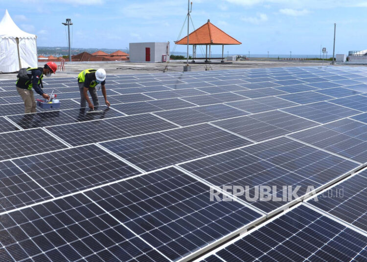 Petugas melakukan perawatan panel surya pada Pembangkit Listrik Tenaga Surya (PLTS) di Bandara I Gusti Ngurah Rai, Badung, Bali, Rabu (21/9/2022). Indef menilai skema power wheeling (pemanfaatan bersama jaringan listrik) dalam RUU Energi Baru dan Terbarukan (EBT) tidak memiliki urgensi.