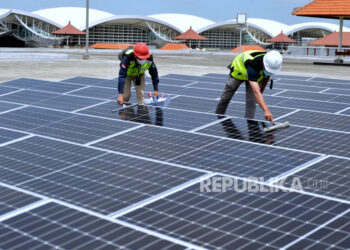 Petugas melakukan perawatan panel surya pada Pembangkit Listrik Tenaga Surya (PLTS) di Bandara I Gusti Ngurah Rai, Badung, Bali, Rabu (21/9/2022). ilustrasi