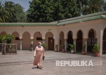 Seorang wanita meninggalkan masjid sambil mengenakan masker di masjid di Rabat, Maroko, Rabu (15/7/2020). Raja Maroko Serukan Warga Sholat Istisqa