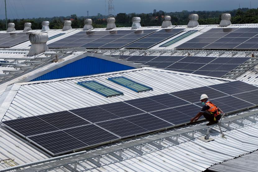 Pekerja memeriksa panel-panel surya dari Pembangkit Listrik Tenaga Surya (PLTS) di atap pabrik Danone-AQUA Mambal di Badung, Bali, Rabu (31/8/2022). PT Bank Mandiri Tbk berkomitmen untuk ikut serta dalam pembiayaan hijau.