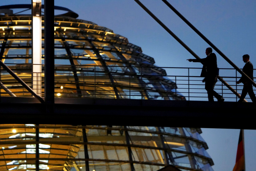 Seseorang menunjuk sambil berjalan di skywalk antara dua gedung pemerintah di depan kubah parlemen federal Jerman, Bundestag, gedung di Berlin, Jerman, Kamis, 10 November 2022.