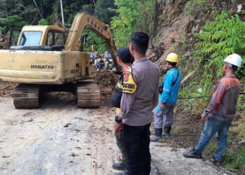 Personel polisi dari Polres Nagan Raya Polda Aceh bersama warga membersihkan jalan yang terkena tanah longsor di jalan lintas Meulaboh—Takengon, tepatnya di Desa Blang Puuk, Kecamatan Beutong Ateuh Banggalang, Nagan Raya, Sabtu (11/11/2023) kemarin. FOTO/Net. Ⓒ Hak cipta foto di atas dikembalikan sesungguhnya kepada pemilik foto