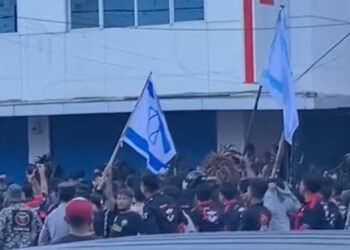 Tangkapan layar video Viral bentrokan antar massa pro teroris Israel dan Pro Palestina di Kota Bitung, Sulawesi Utara. Dari kejauhan terlihat seorang pendukung pro negara teroris Israel mengibarkan bendara Zionis. FOTO/Instagram. Ⓒ Hak cipta foto di atas dikembalikan sesungguhnya kepada pemilik foto
