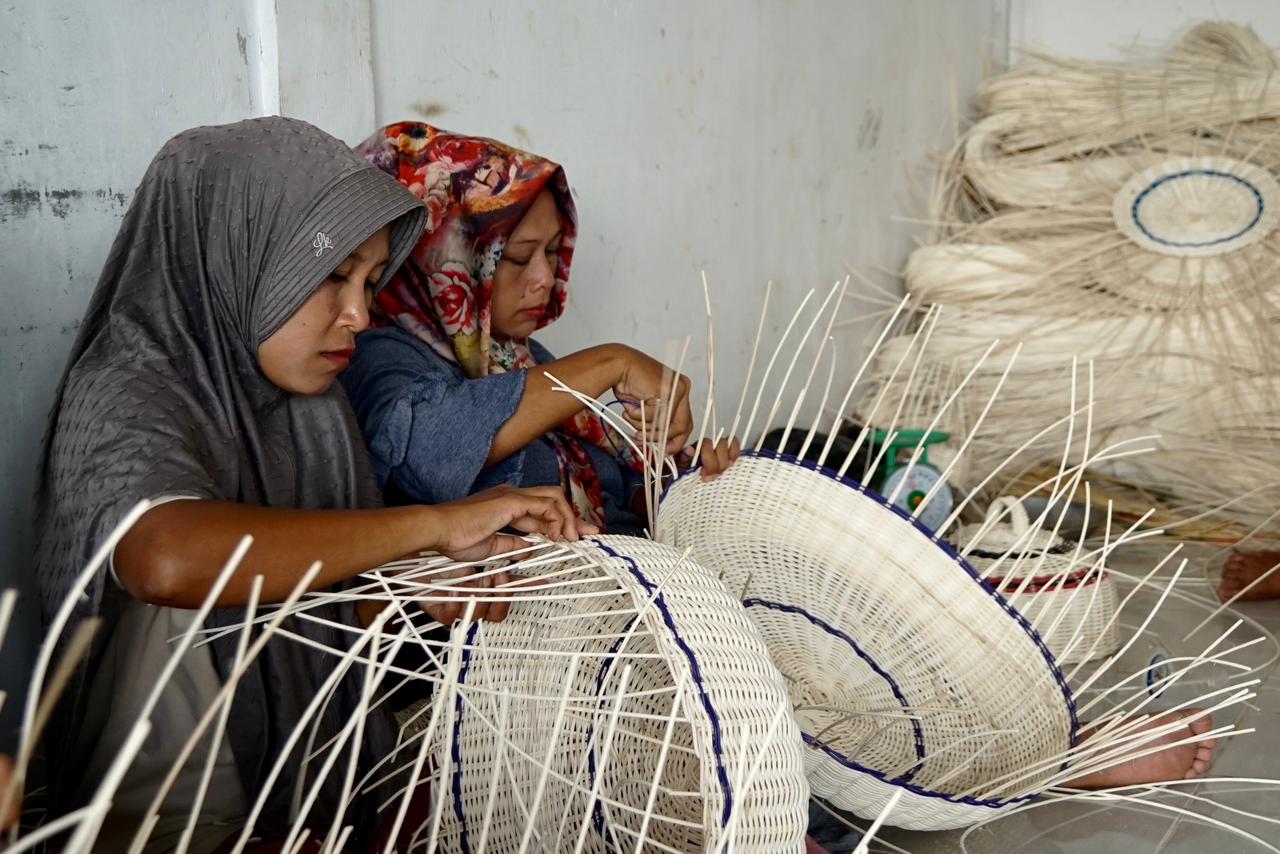 Ibu-ibu rumah tangga sibuk merangkai batang rotan, menyambung batang demi batang menjadi piring rotan, tudung saji dan keranjang buah. FOTO/HAI/Fendra Tryshanie. Ⓒ Hak cipta foto di atas dikembalikan sesungguhnya kepada pemilik foto