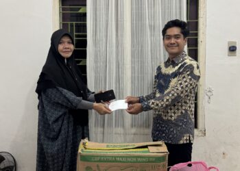 Ketua BEM Fakultas Hukum, Annas Maulana sedang menyerahkan bantuan dari bentuk kepedulian mahasiswa terhadap masyarakat sekitar. FOTO/Dok. BEM Fakultas Hukum USK. Ⓒ Hak cipta foto di atas dikembalikan sesungguhnya kepada pemilik foto