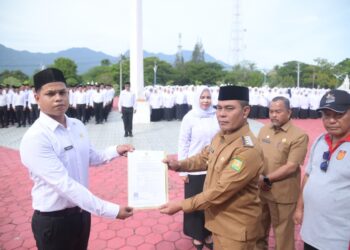 Bupati Aceh Besar, Muharram Idris menyerahkan Surat Keputusan (SK) pengangkatan 890 Pegawai Pemerintah dengan Perjanjian Kerja (PPPK) tahap I di lingkungan Pemkab Aceh Besar. FOTO/Net.