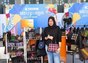 Pemilik Nani Souvenir Aceh Besar memamerkan produk unggulan seperti tas, songket, dan dompet Karawang pada Expo UMKM Meuseuraya Festival 2025 di Bale Meuseuraya Aceh, Banda Aceh