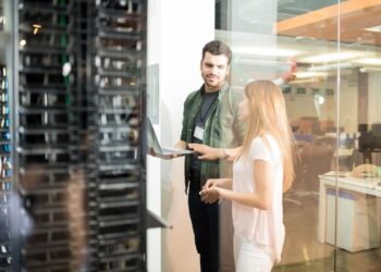 Colleagues discussing in office server room. FOTO/Freepik.