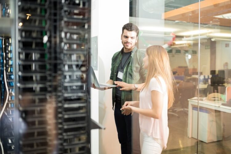 Colleagues discussing in office server room. FOTO/Freepik.