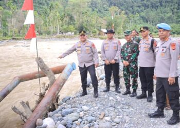 Menindaklanjuti arahan Kapolri terkait jembatan darurat yang viral karena membahayakan keselamatan anak-anak sekolah, Kapolda Aceh Irjen Pol. Ruddi Setiawan yang diwakili Irwasda Polda Aceh Kombes Pol. Iskandar ZA meninjau langsung kondisi jembatan tali baja darurat di Desa Sikundo, Kecamatan Pante Ceureumen, Kabupaten Aceh Barat, Kamis (23/7/2026). FOTO/Dok. Polda Aceh.