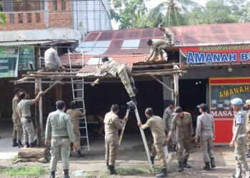 Memasuki hari ketiga penertiban, Satuan Polisi Pamong Praja dan Wilayatul Hisbah (Satpol PP dan WH) Kabupaten Aceh Besar kembali membongkar sejumlah bangunan dan lapak pedagang yang melanggar aturan di kawasan pintu masuk Bandara Sultan Iskandar Muda (SIM), Kecamatan Blang Bintang, Aceh Besar, Rabu (21/10/2026). FOTO/Net.