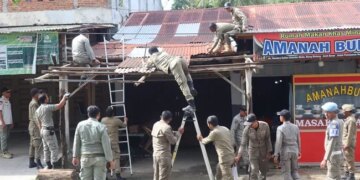 Memasuki hari ketiga penertiban, Satuan Polisi Pamong Praja dan Wilayatul Hisbah (Satpol PP dan WH) Kabupaten Aceh Besar kembali membongkar sejumlah bangunan dan lapak pedagang yang melanggar aturan di kawasan pintu masuk Bandara Sultan Iskandar Muda (SIM), Kecamatan Blang Bintang, Aceh Besar, Rabu (21/10/2026). FOTO/Net.