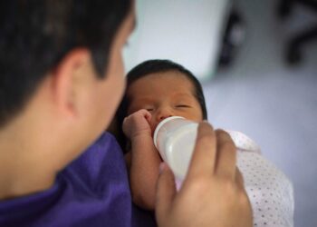 Seorang ayah sedang memberikan susu formula ke pada bayinya. FOTO/Pexels. Ⓒ Hak cipta foto di atas dikembalikan sesungguhnya kepada pemilik foto